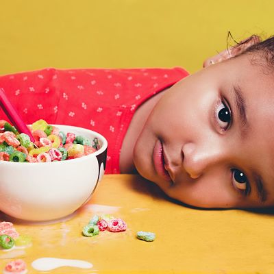 Niño con bol y cereales de caja